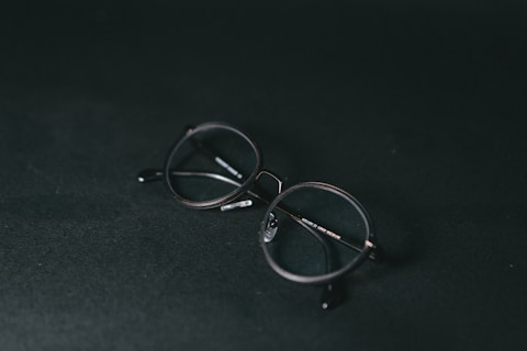 silver framed eyeglasses on black textile