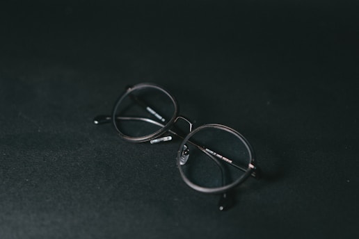 silver framed eyeglasses on black textile