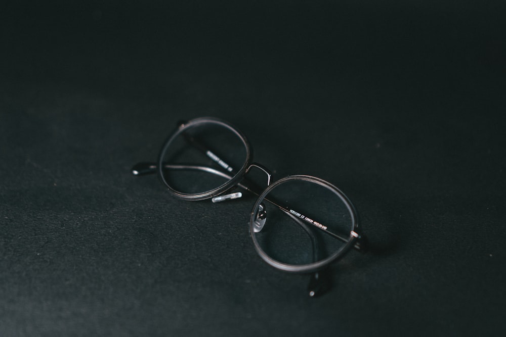 silver framed eyeglasses on black textile