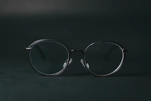 Transparent transition lenses on a minimalist black frame against a dark background
