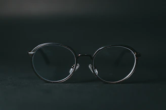 Side view of modern black eyeglasses with thin frames on a minimalist dark background