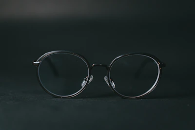 Side view of modern black eyeglasses with thin frames on a minimalist dark background