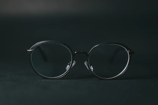 Transparent transition lenses on a minimalist black frame against a dark background