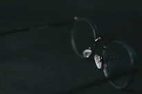 Close-up of premium eyeglasses resting on a minimalist white surface with soft lighting.