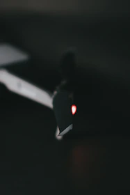 Close-up of a drone mid-flight against a dark background illuminated by electric purple lights.