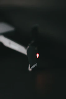 Close-up of a drone technician carefully inspecting rotor blades under soft blue lighting.