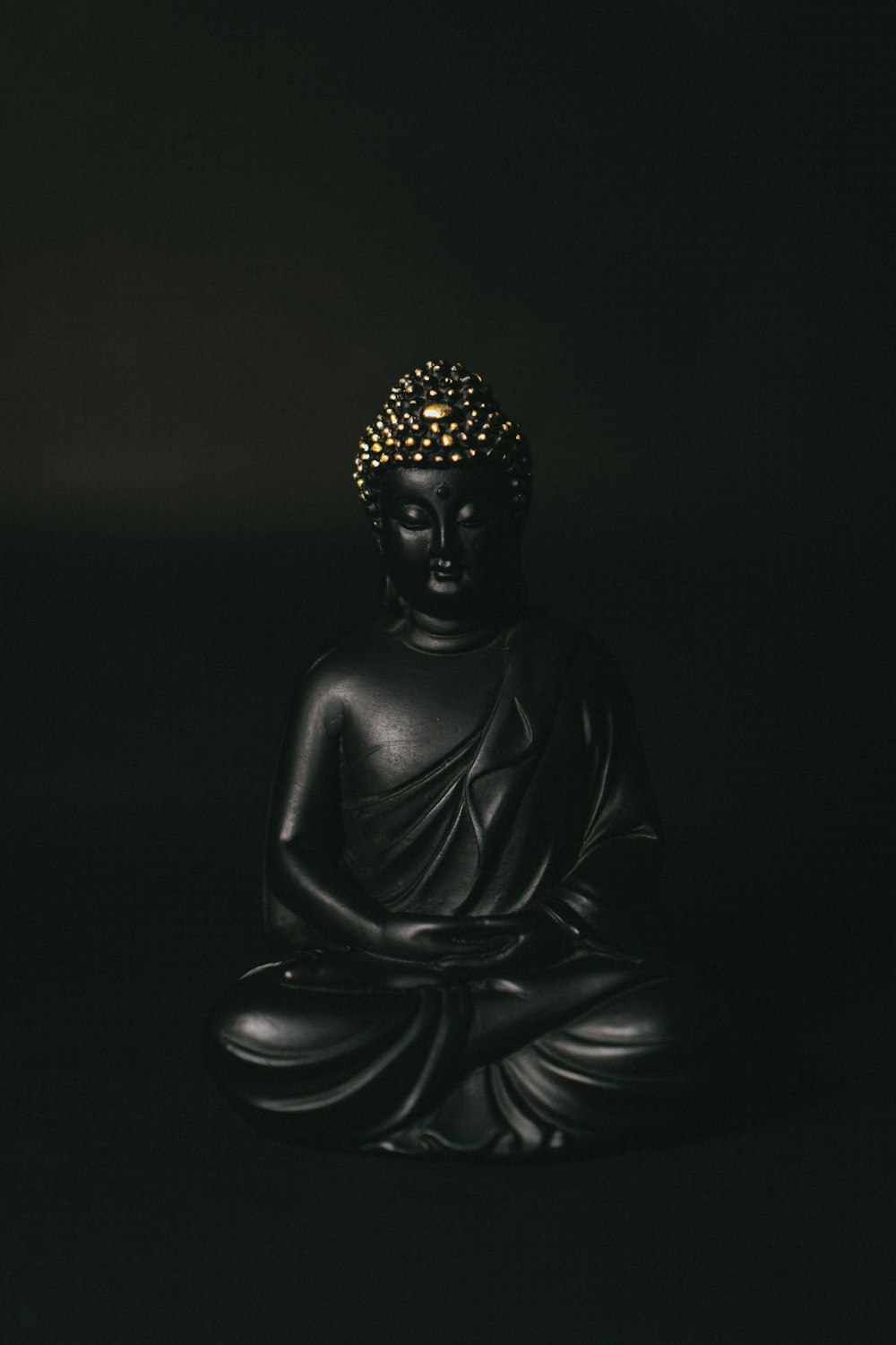 Schwarze Gautama Buddha Statue auf schwarzem Hintergrund