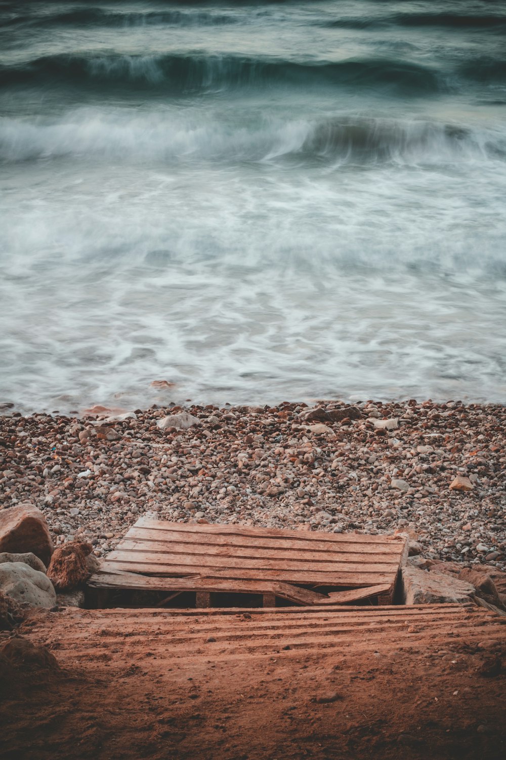 brown wooden bench near body of water during daytime