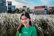 woman in blue crew neck shirt standing on green grass field during daytime