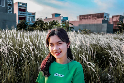 woman in blue crew neck shirt standing on green grass field during daytime
