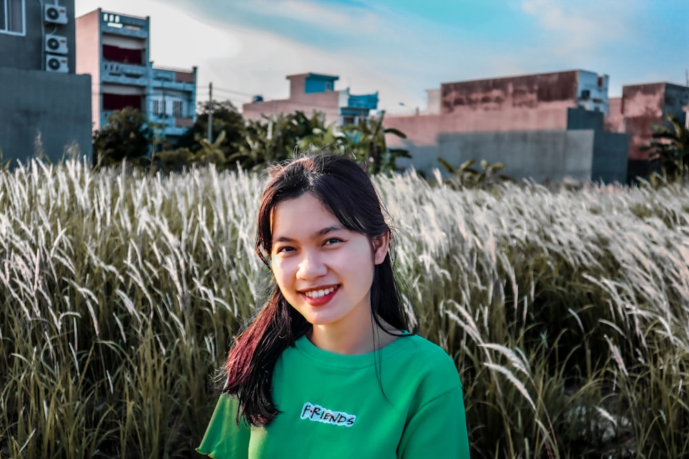 woman in blue crew neck shirt standing on green grass field during daytime