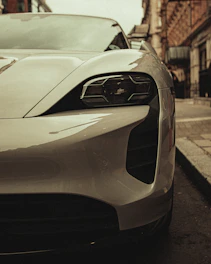 Close-up of a vintage car’s headlight reflecting the surrounding architecture in soft light.