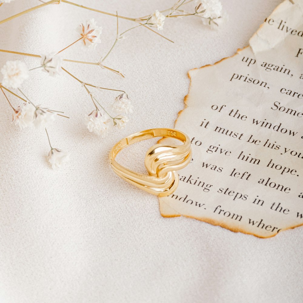 gold ring on white textile