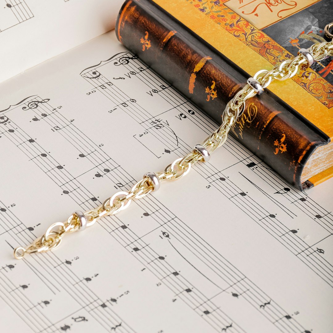 gold chain necklace on musical note sheet