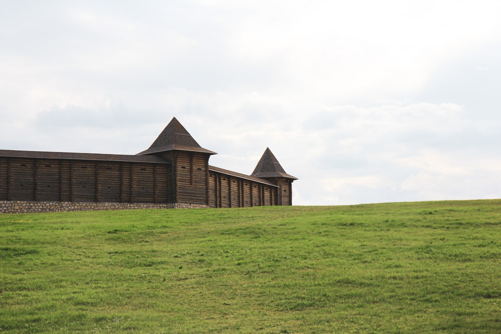 brown brick building on green grass field under white sky during daytime