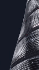 A sleek modern corporate tower with integrated smart building systems glowing at dusk.