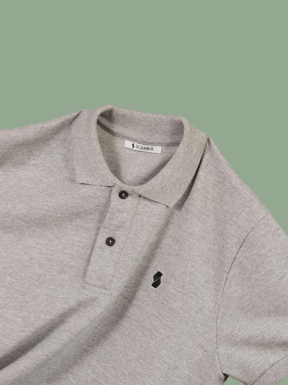 Polo gris sobre textil azul