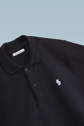 Close-up of a sleek black marell polo shirt with fine stitching and embroidered logo on a white background.