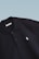 Close-up of embroidered school crest on a Galvanni polo shirt.