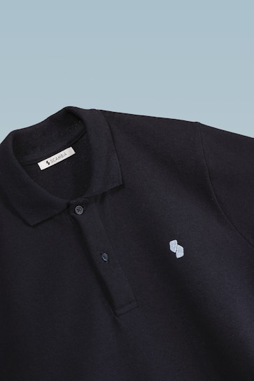 A close-up shot of a navy blue polo shirt with a subtle embroidered logo, laid out on a wooden table.