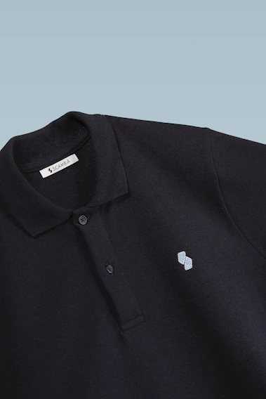 Close-up of a premium navy blue polo shirt with fine stitching and a soft collar.