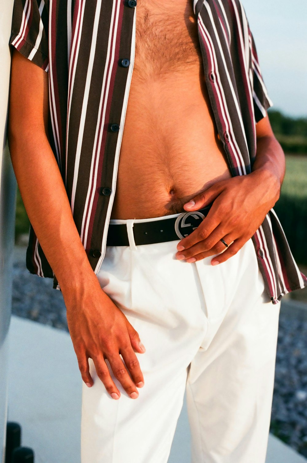 man in black and white striped button up shirt and white pants