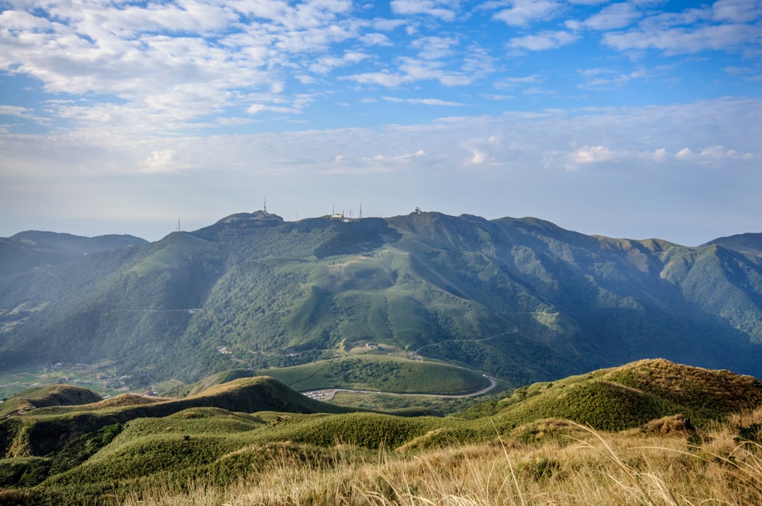 green grass covered mountain under blue sky during daytime