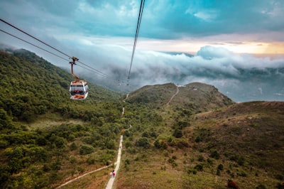 red and white cable car over green grass field during daytime visually stimulating teams background