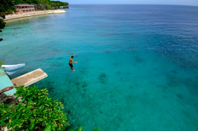 woman in black bikini swimming on blue sea during daytime visually stimulating zoom background