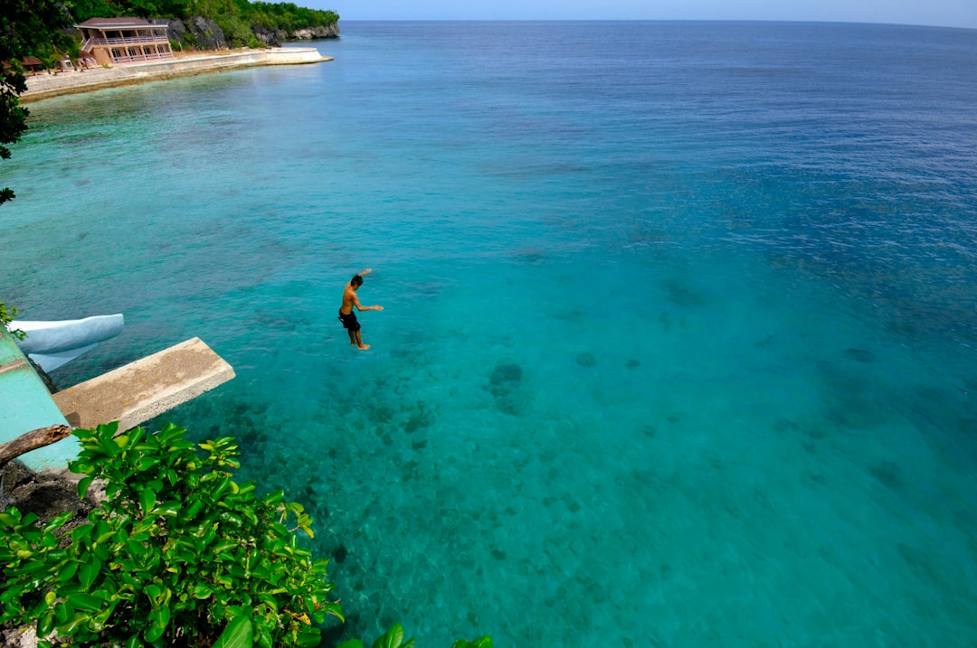 woman in black bikini swimming on blue sea during daytime