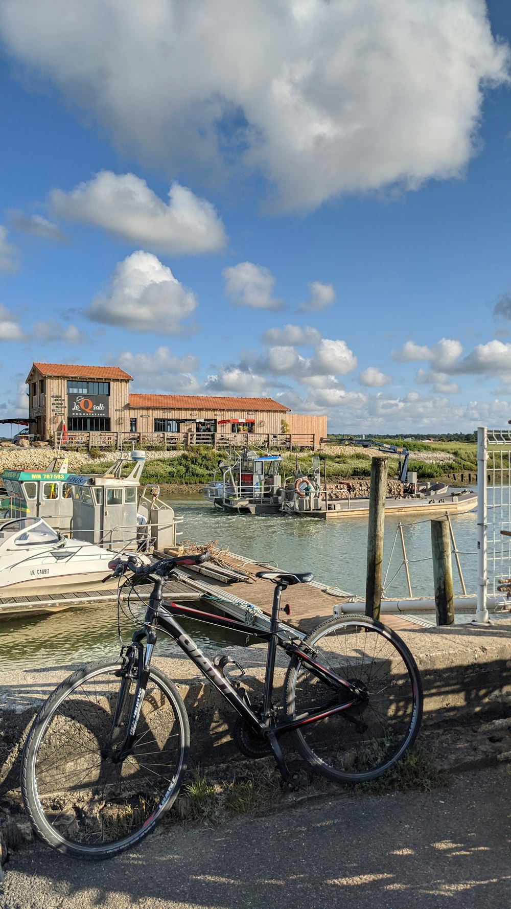 black bicycle beside white boat on dock during daytime