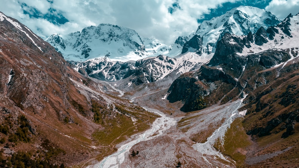 Montañas cubiertas de nieve bajo el cielo nublado durante el día