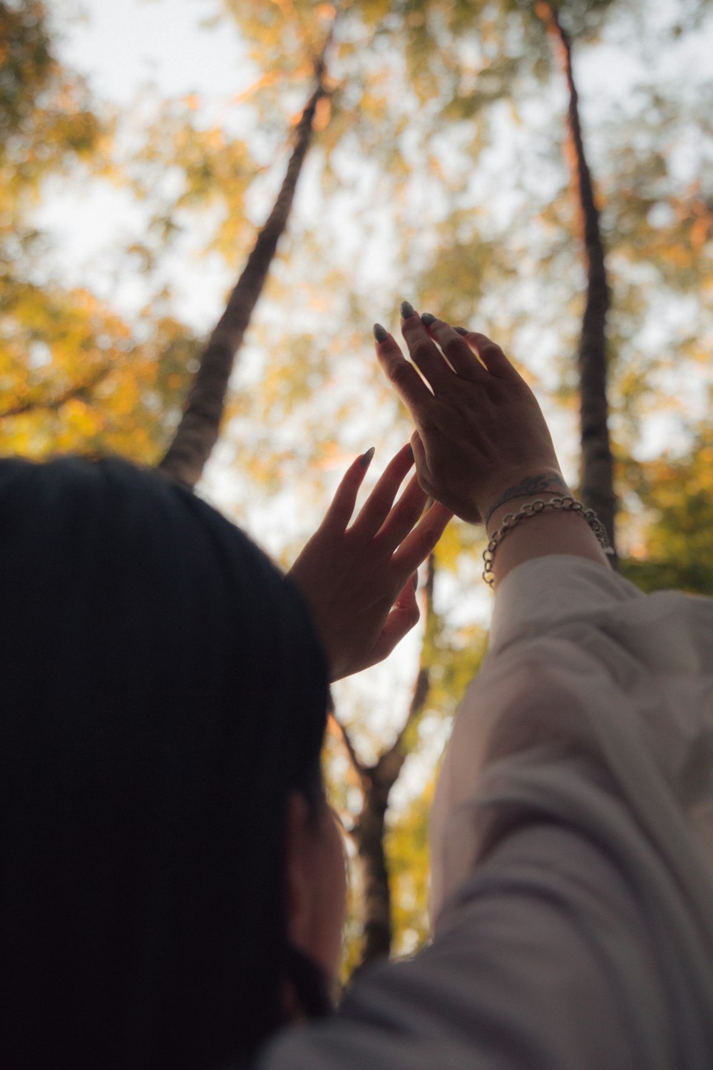 person in white long sleeve shirt wearing silver bracelet