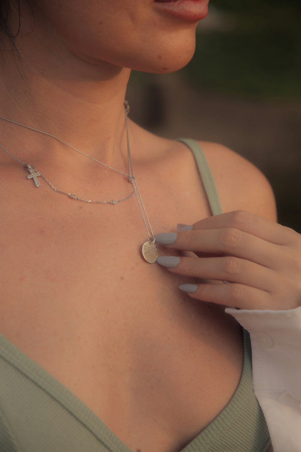 woman in white tank top wearing silver necklace