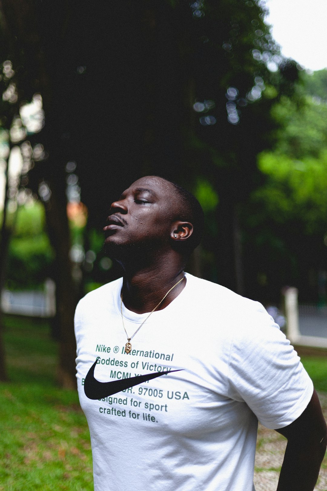 man in white crew neck t-shirt standing on green grass field during daytime