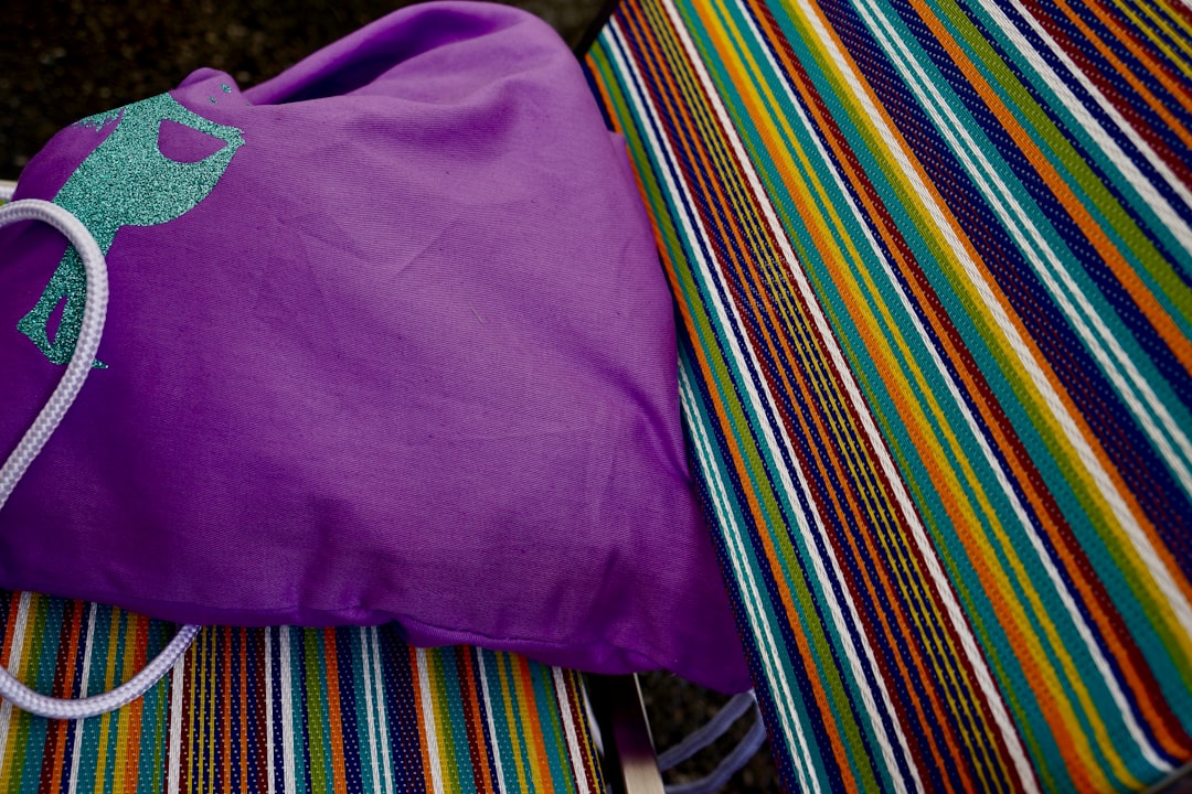 purple crew neck shirt on multi colored striped textile