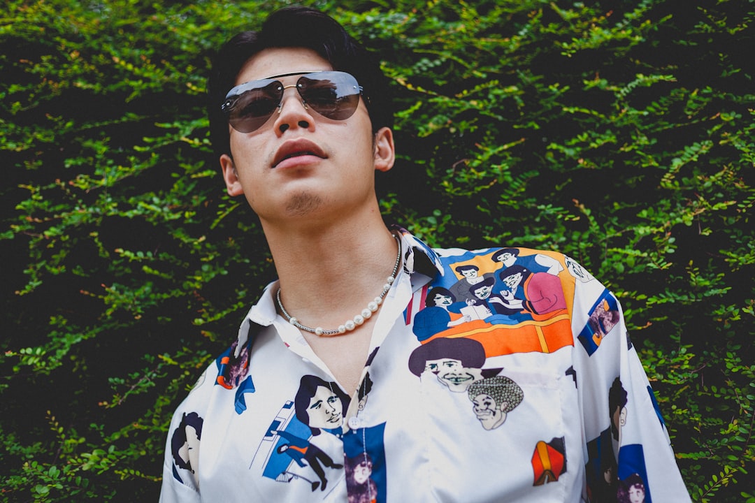 man in white blue and yellow floral button up shirt wearing black sunglasses
