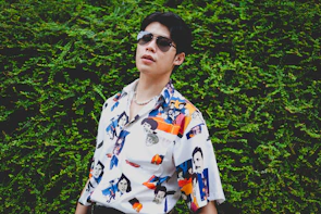 Model wearing a colorful ultrarealistic 80s style t-shirt with geometric patterns.