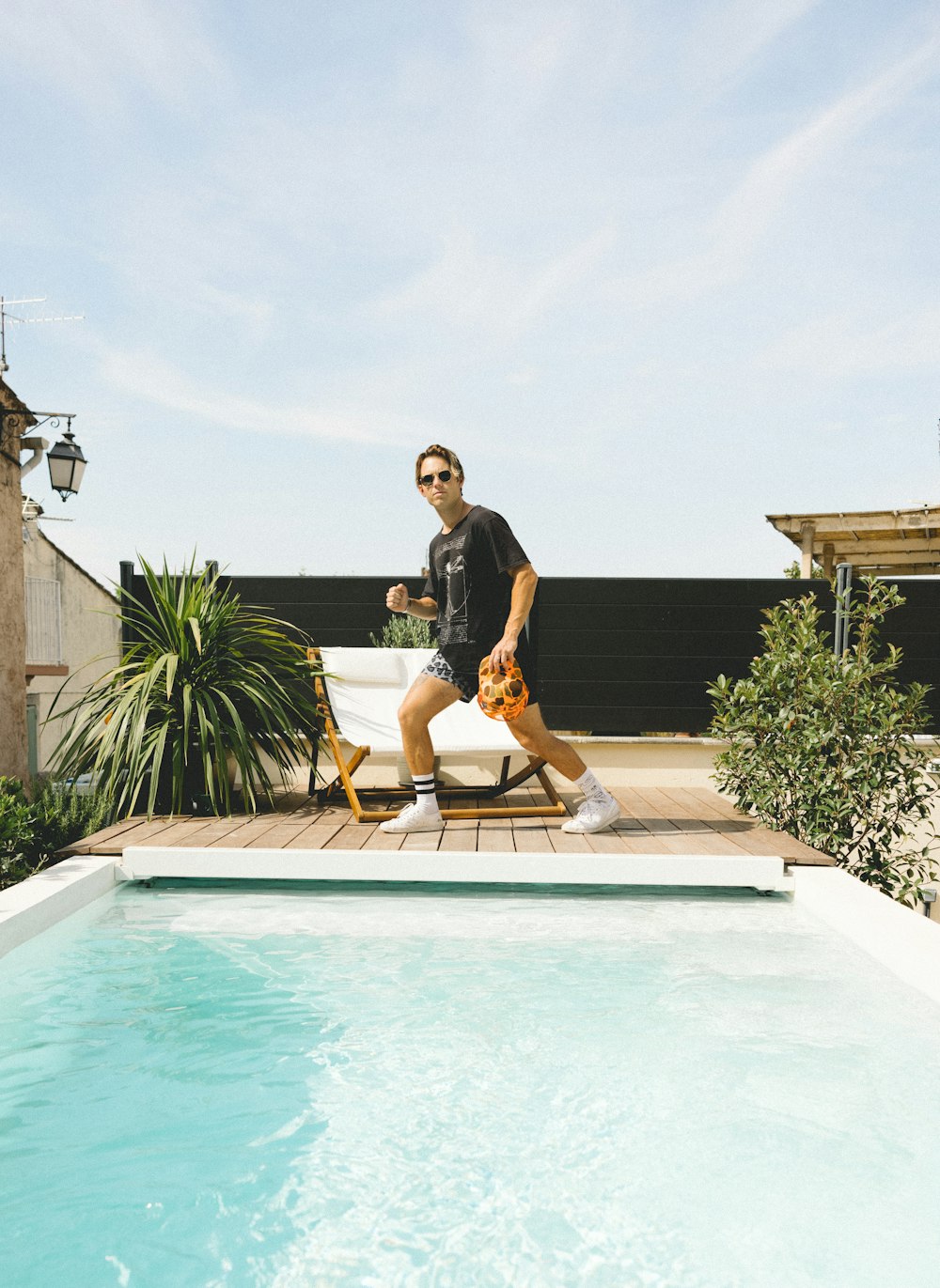 femme en chemise noire et short jaune debout sur la piscine pendant la journée