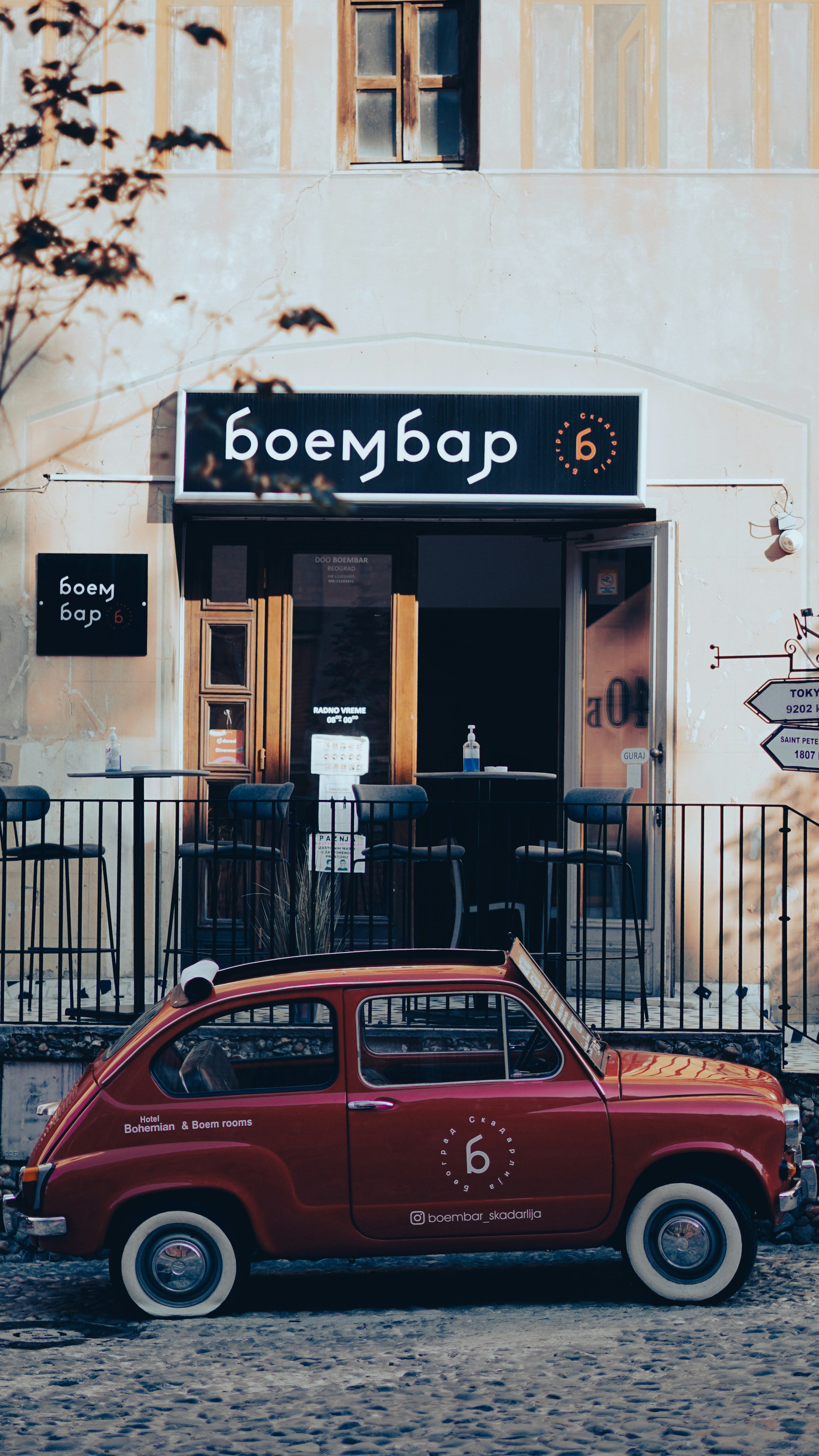 red car parked in front of white building
