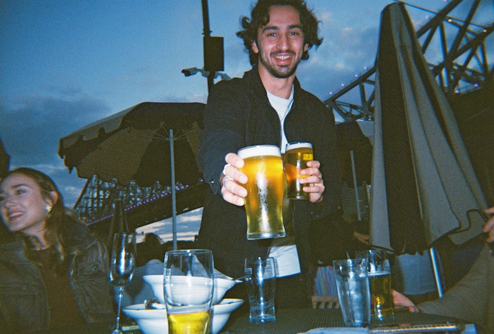 man in black suit holding beer mug