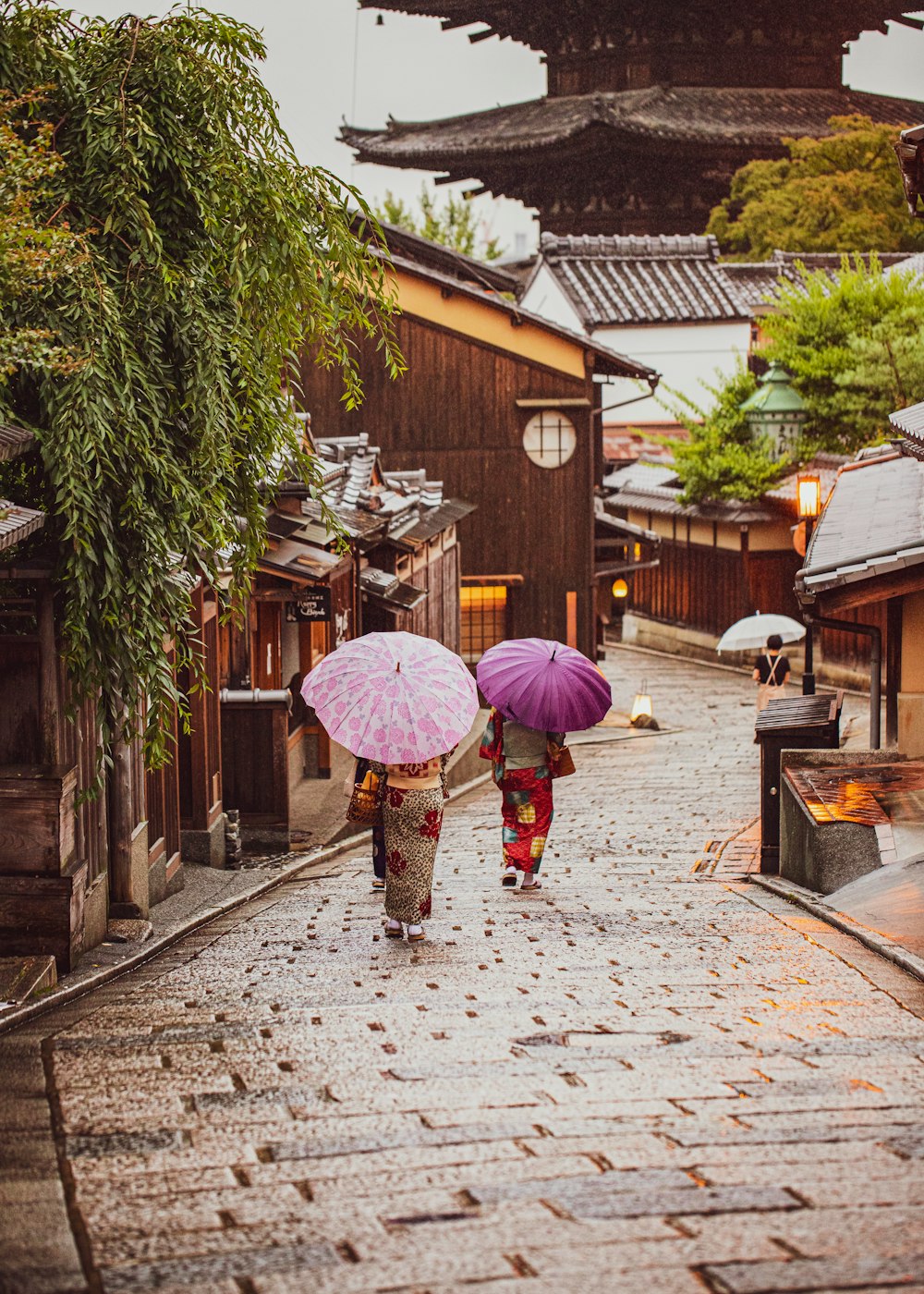 woman in pink umbrella walking on sidewalk during daytime