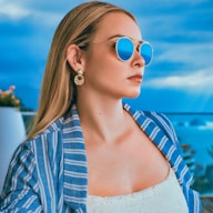 woman in blue and white striped shirt wearing aviator sunglasses