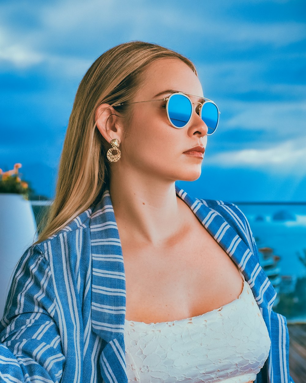 woman in blue and white striped shirt wearing aviator sunglasses