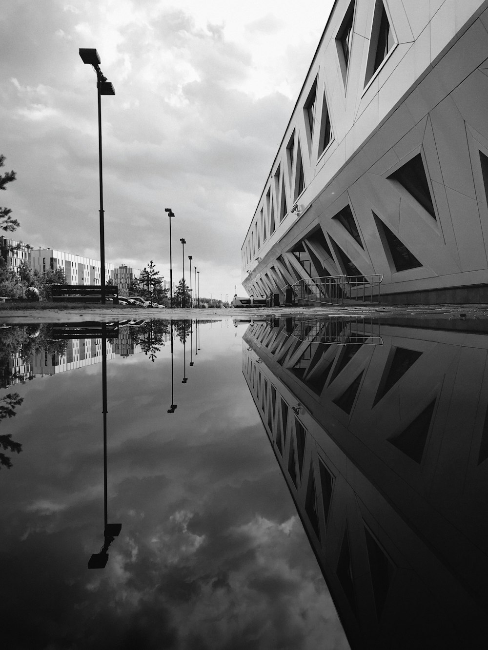 Foto en escala de grises de un edificio cerca de un cuerpo de agua