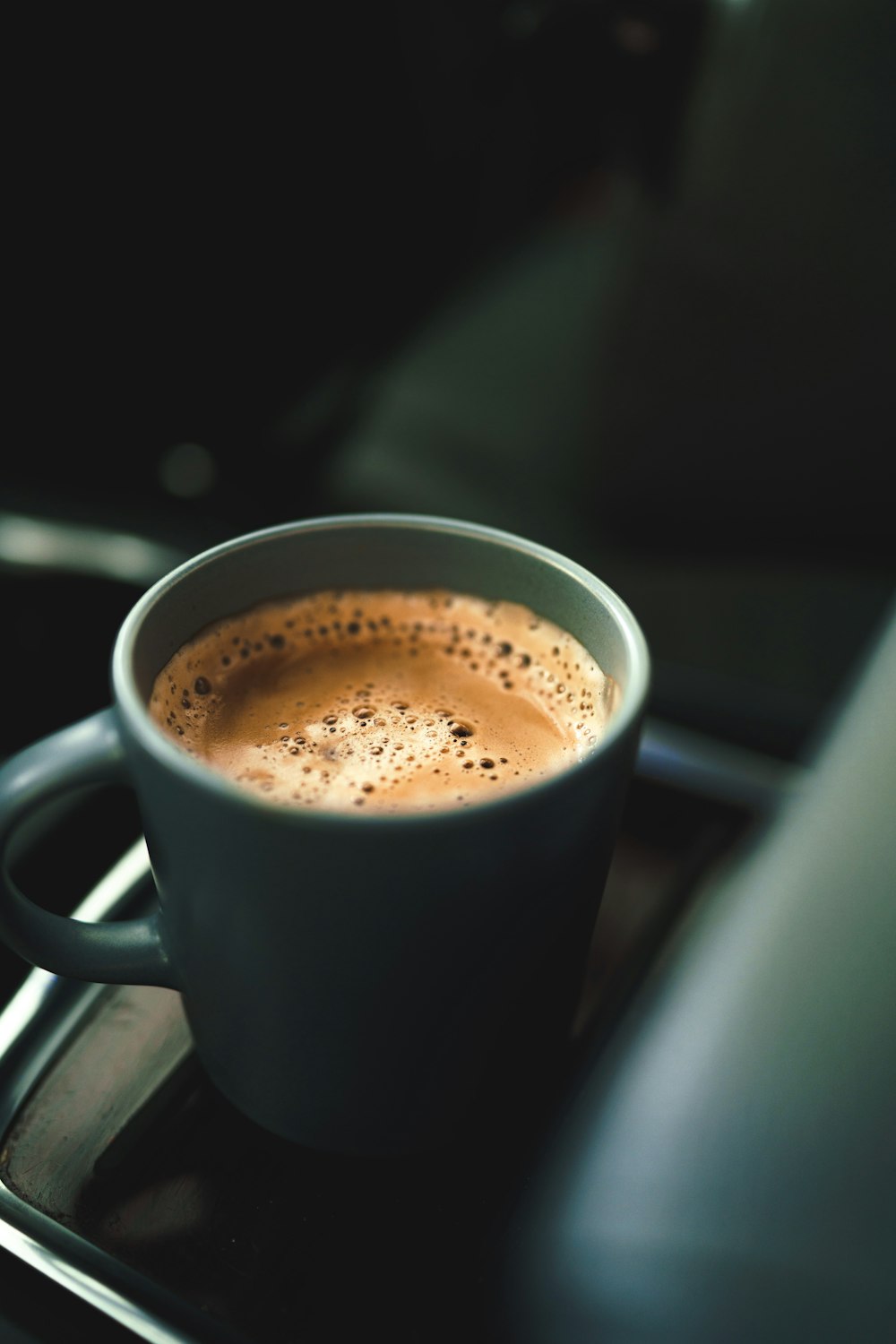 black ceramic mug with brown liquid inside