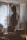 man in black and orange jacket standing near window