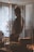 man in black and orange jacket standing near window
