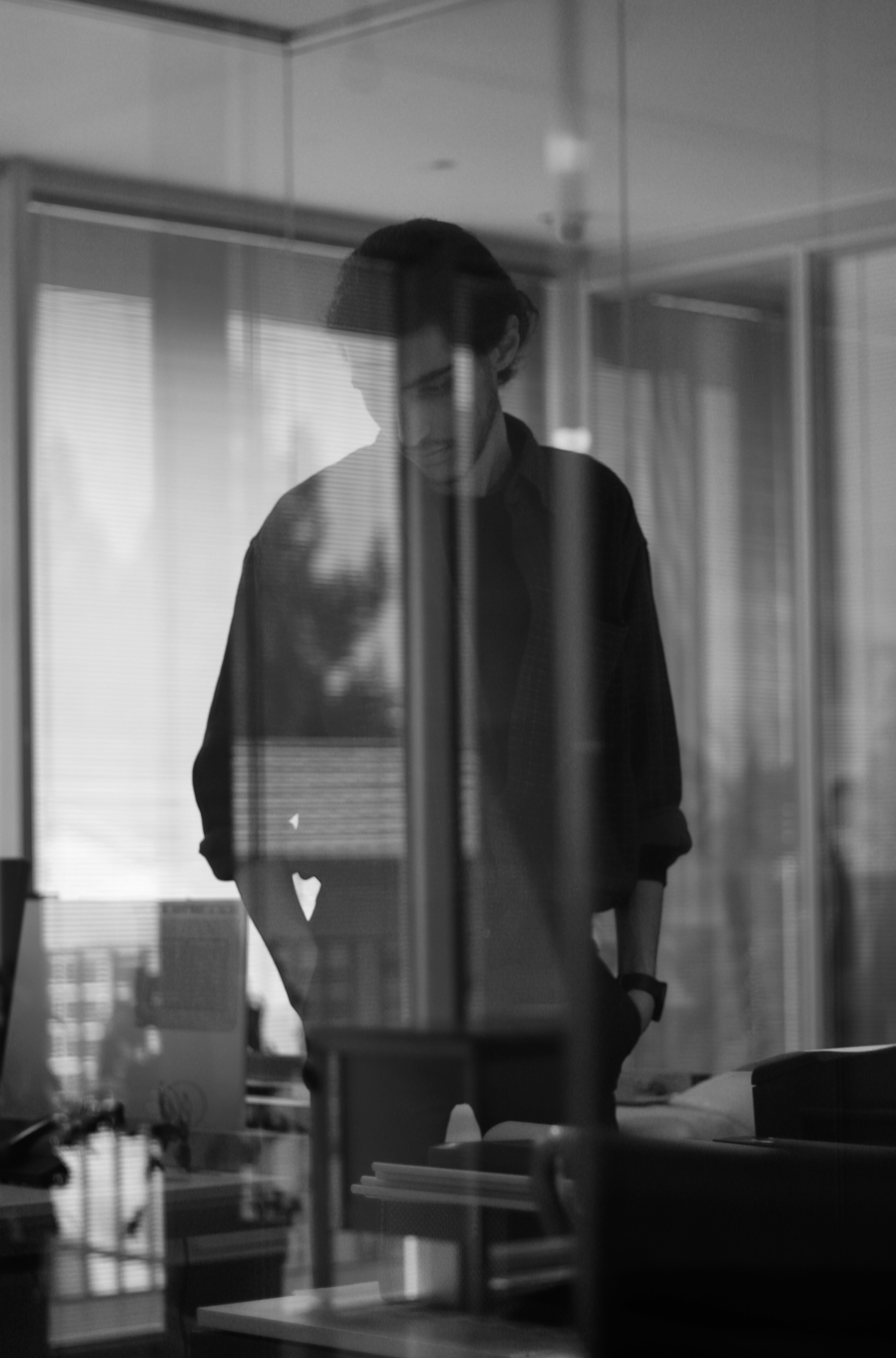 man in black long sleeve shirt standing near window