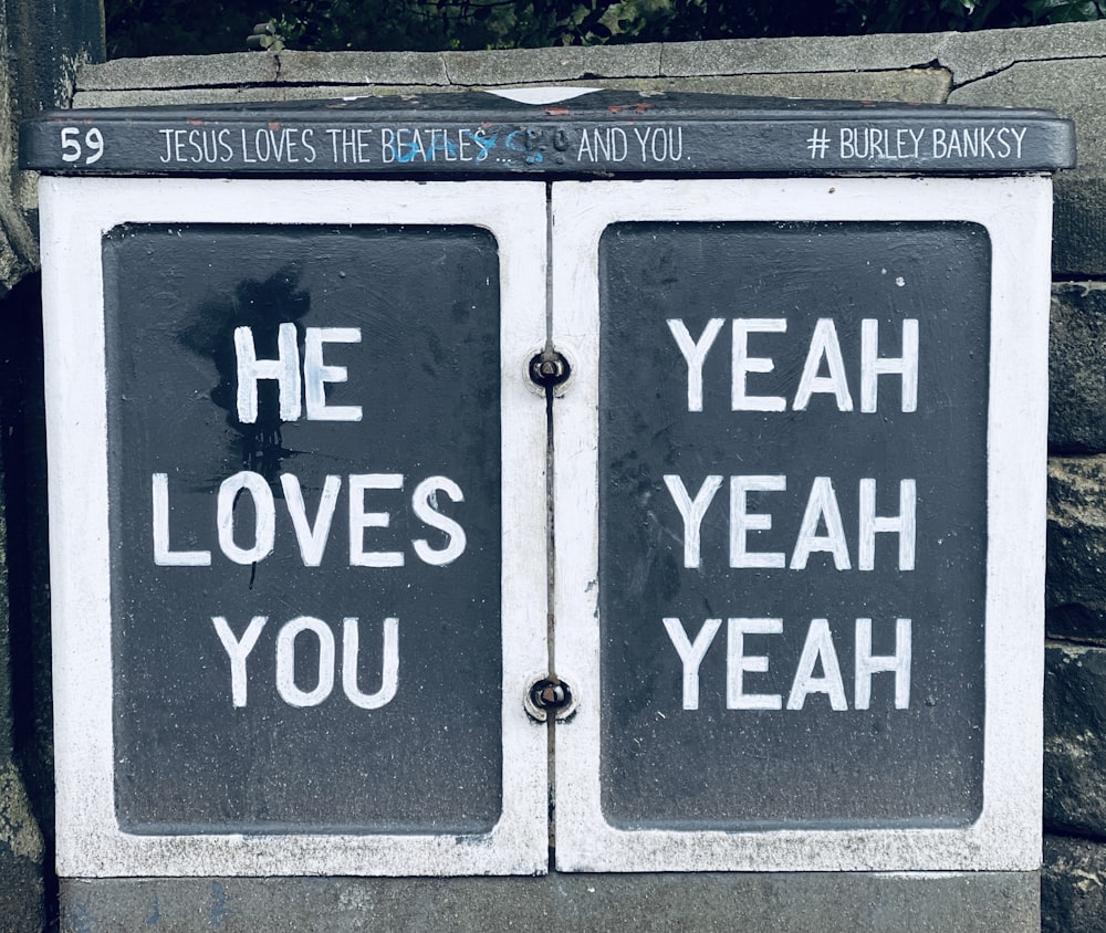 a couple of black and white signs on a stone wall